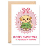 Christmas card with a cartoon dog in a green sweater and candy cane, surrounded by pink polka dots and a bow.